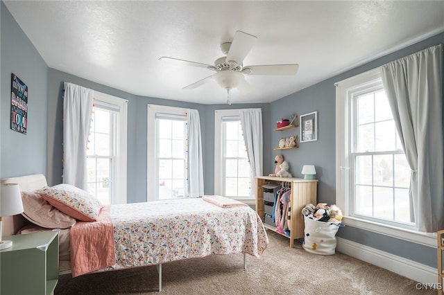 bedroom featuring carpet flooring, multiple windows, and ceiling fan