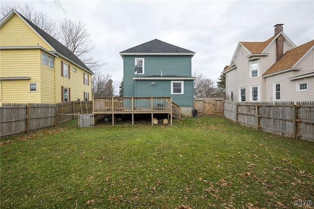 rear view of property with a lawn and a deck