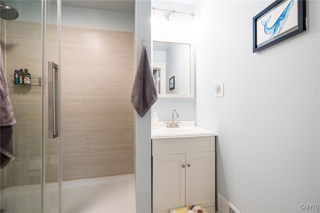 bathroom with a shower with door and vanity