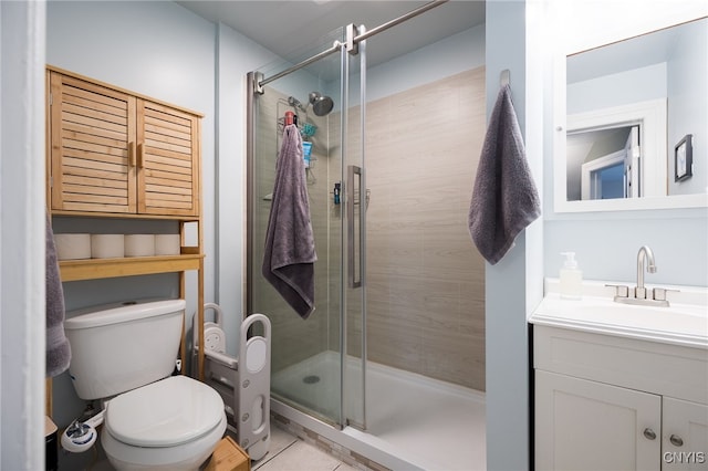 bathroom with tile patterned floors, vanity, toilet, and a shower with shower door