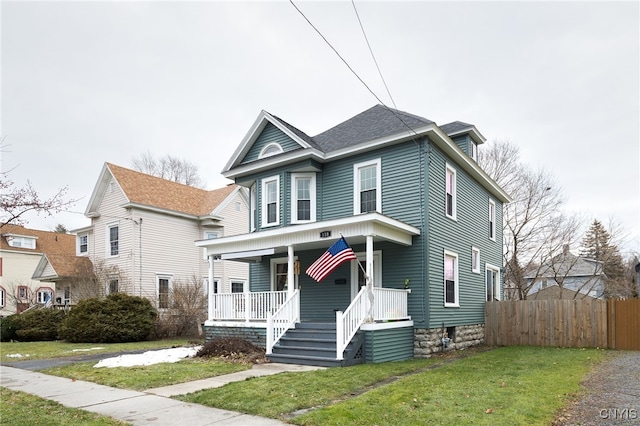 view of front of home featuring covered porch and a front lawn