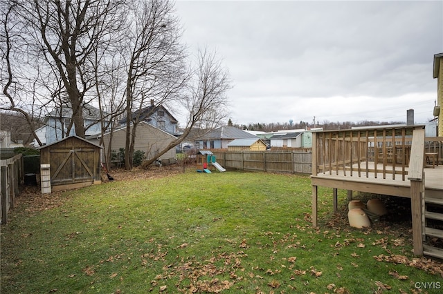 view of yard with a playground, a shed, and a deck