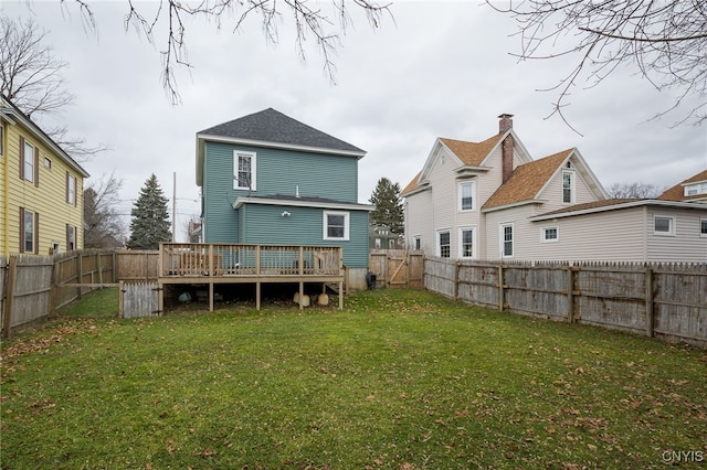 rear view of property featuring a wooden deck and a yard