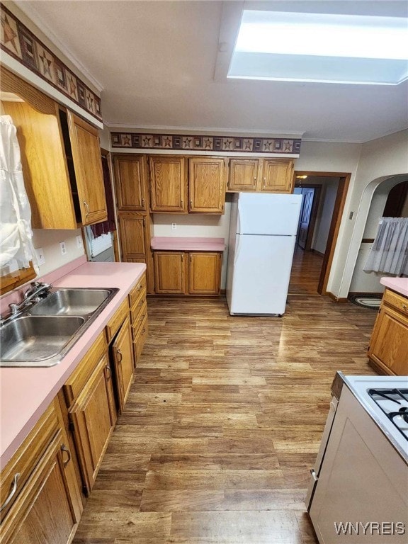 kitchen with sink, light hardwood / wood-style floors, and white appliances