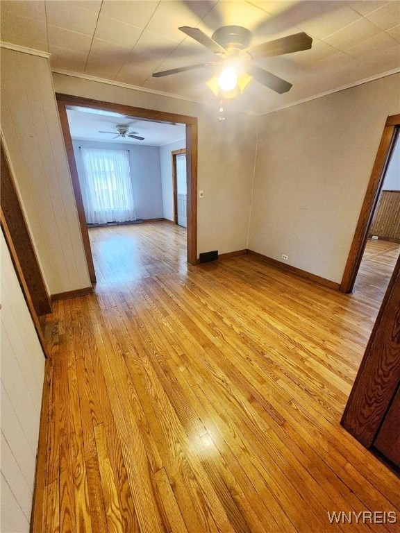 empty room with crown molding, light hardwood / wood-style flooring, and ceiling fan