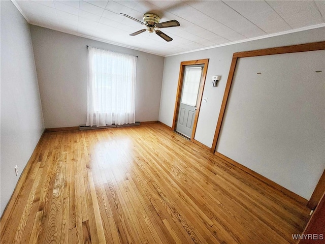 empty room featuring crown molding, light hardwood / wood-style flooring, and ceiling fan