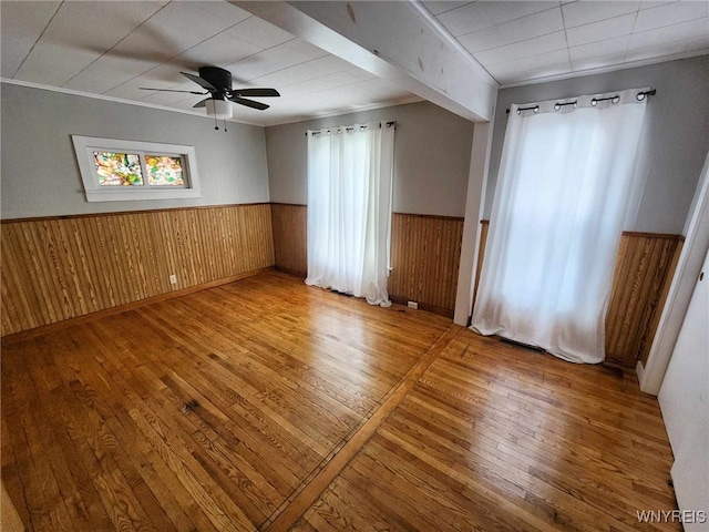 spare room featuring hardwood / wood-style flooring, plenty of natural light, ceiling fan, and ornamental molding