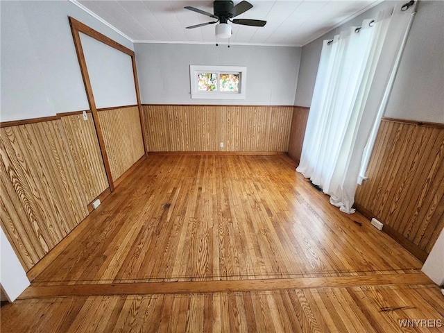 unfurnished room with crown molding, ceiling fan, and light wood-type flooring