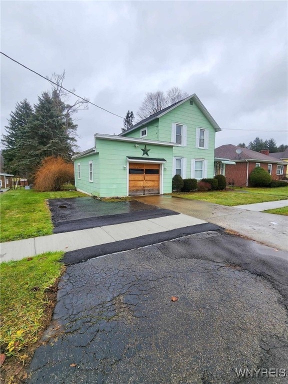 view of front of property featuring a garage and a front yard