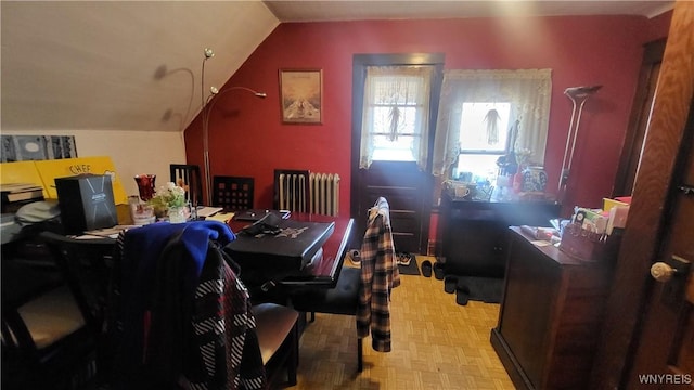 interior space featuring light parquet floors, radiator heating unit, and vaulted ceiling