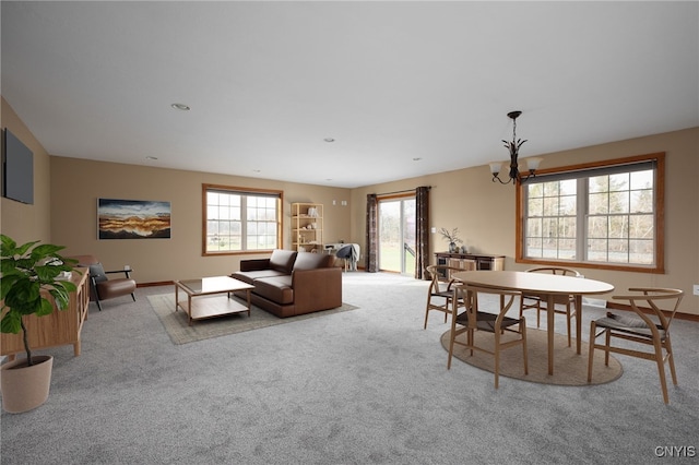 carpeted dining area featuring a wealth of natural light and an inviting chandelier