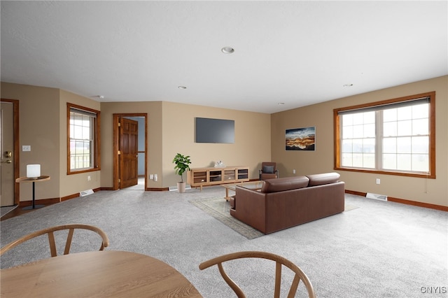 living room featuring light colored carpet and a healthy amount of sunlight