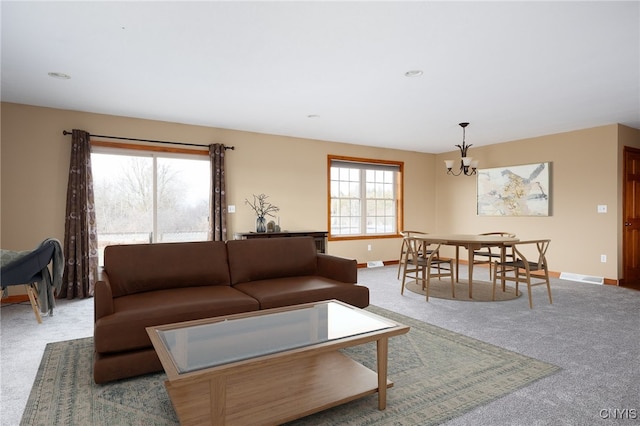 living room featuring carpet, an inviting chandelier, and a wealth of natural light