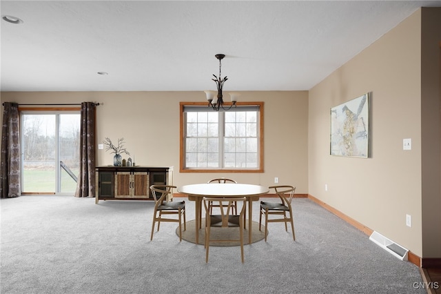 dining room featuring carpet flooring and a notable chandelier