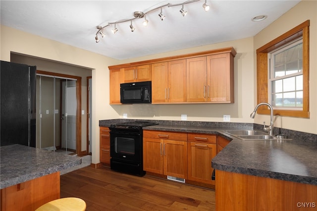 kitchen with dark hardwood / wood-style flooring, sink, and black appliances