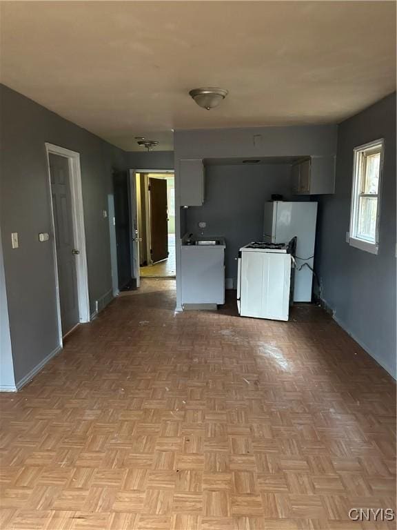 kitchen featuring white cabinets, white appliances, and light parquet floors