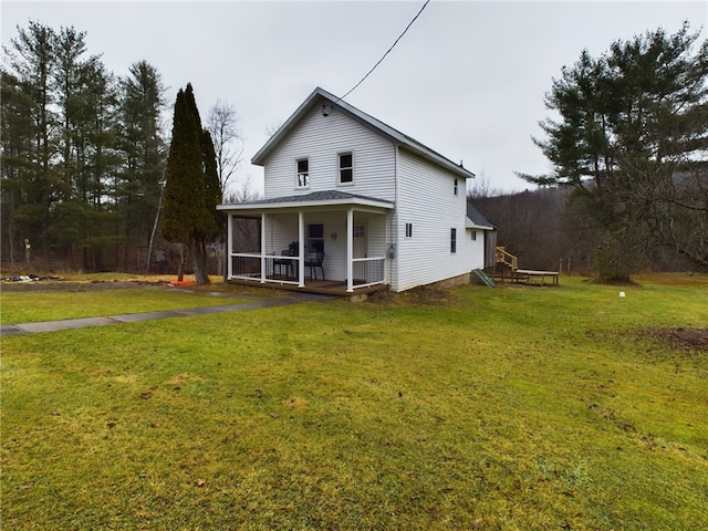 rear view of house with a porch and a yard