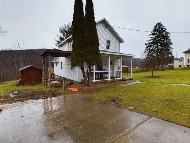 view of home's exterior with a lawn, a shed, and a porch