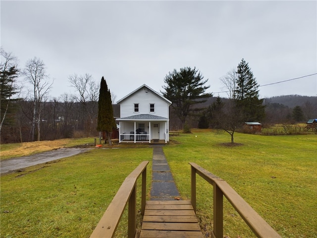 back of house featuring a yard and covered porch