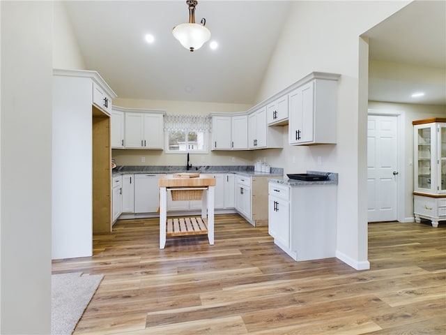 kitchen with white cabinets, pendant lighting, white dishwasher, and light hardwood / wood-style flooring