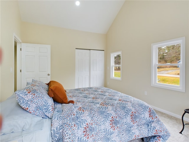 carpeted bedroom with vaulted ceiling and a closet