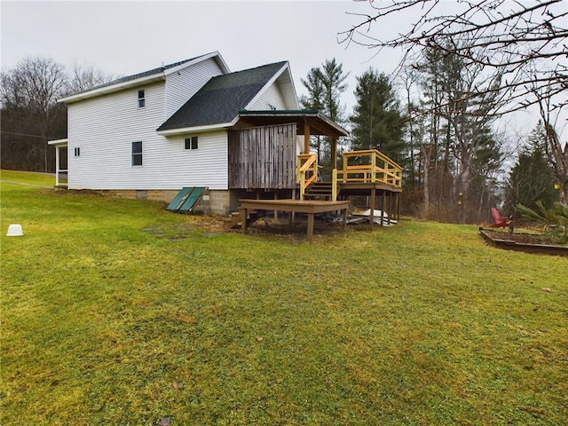 rear view of property with a yard and a deck