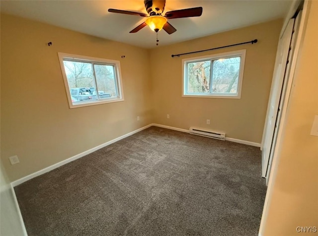 carpeted empty room featuring ceiling fan and a baseboard radiator