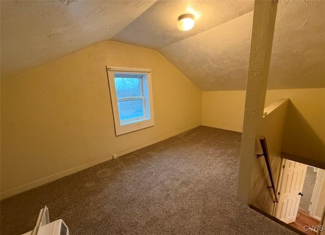 bonus room featuring carpet flooring, lofted ceiling, and a textured ceiling