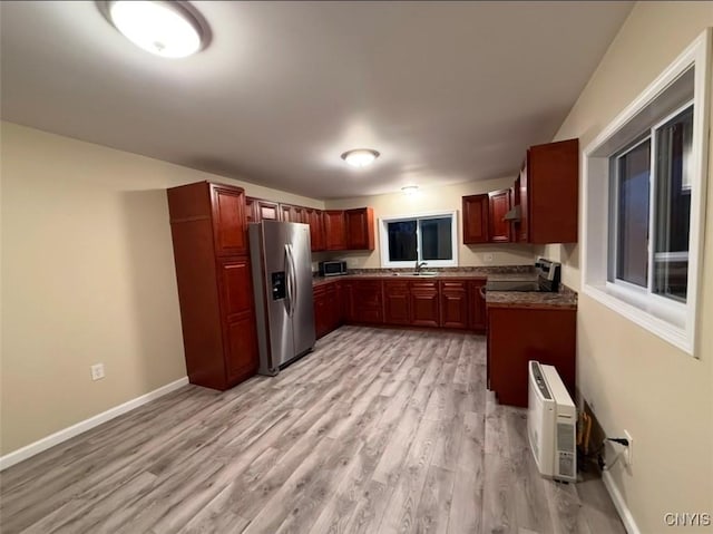 kitchen featuring stainless steel appliances, light hardwood / wood-style floors, and sink