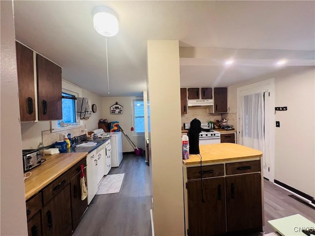 kitchen with dark brown cabinets, dark wood-type flooring, white stove, and washer / dryer