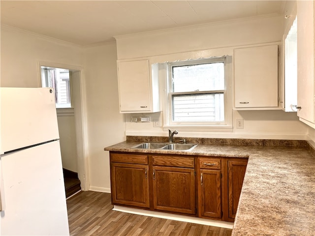 kitchen with white fridge, crown molding, sink, and light hardwood / wood-style flooring