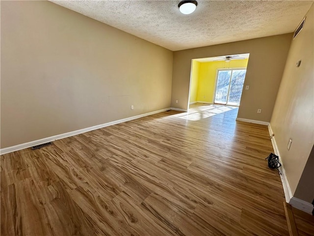 spare room featuring ceiling fan, light hardwood / wood-style floors, and a textured ceiling