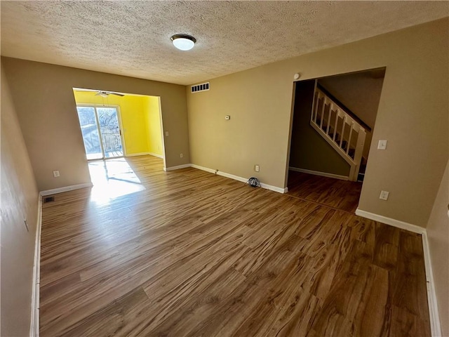 spare room with hardwood / wood-style floors and a textured ceiling