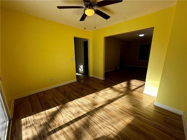 spare room featuring ceiling fan and dark hardwood / wood-style floors