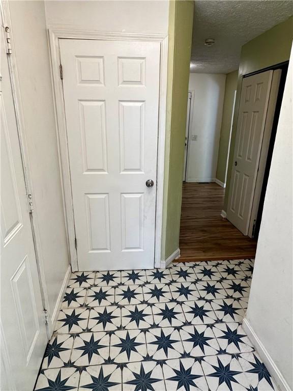 hallway with a textured ceiling