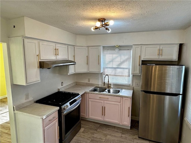 kitchen with white cabinets, appliances with stainless steel finishes, a textured ceiling, and sink