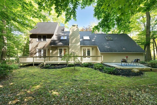 back of property featuring a lawn, a patio, a wooden deck, and french doors