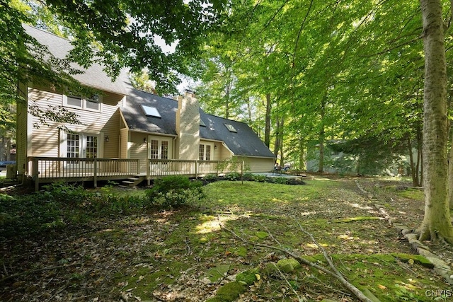 view of yard with a wooden deck and french doors