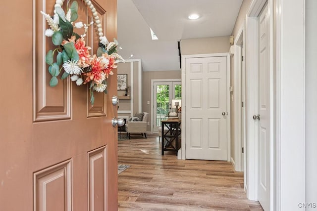 hallway with light wood-type flooring and french doors