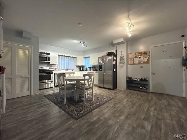 dining area with rail lighting and wood-type flooring