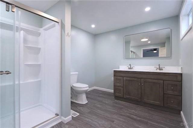 bathroom featuring vanity, hardwood / wood-style flooring, toilet, and a shower with shower door