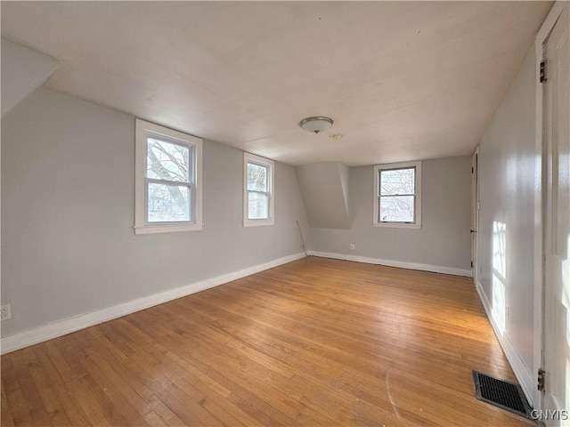 additional living space with light hardwood / wood-style flooring