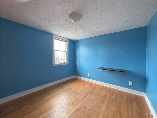 spare room with hardwood / wood-style floors and a textured ceiling