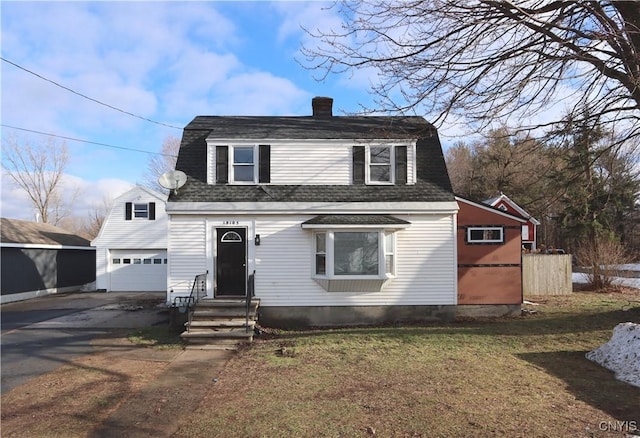 view of front of home with a front yard, an outbuilding, and a garage