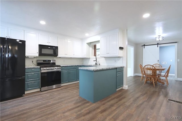 kitchen featuring black appliances, a barn door, white cabinets, and dark wood-type flooring