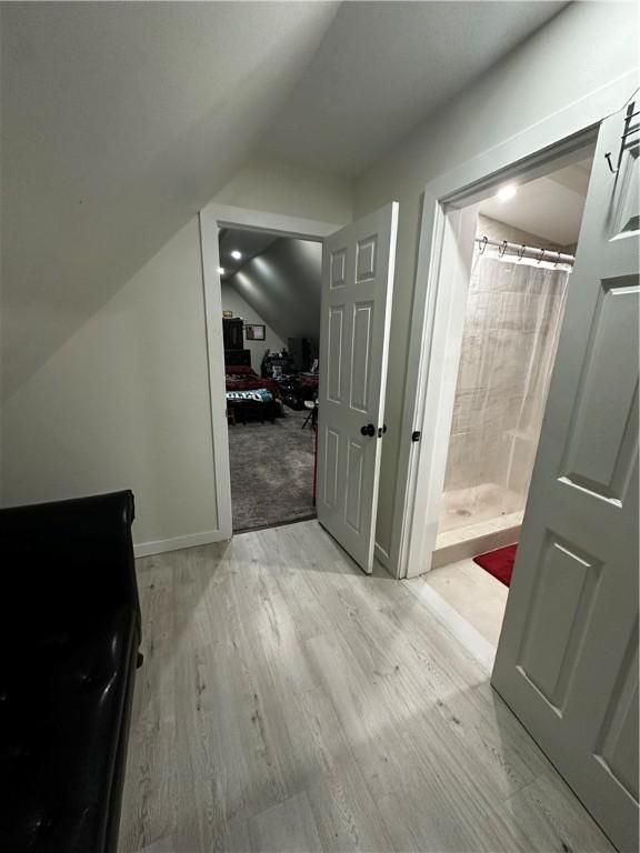 bonus room featuring vaulted ceiling and light wood-type flooring