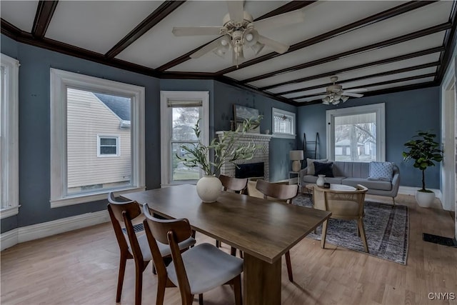 dining area with ceiling fan, light hardwood / wood-style flooring, and beamed ceiling