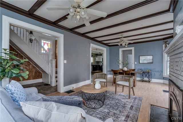 living room featuring beamed ceiling, plenty of natural light, wood-type flooring, and ornamental molding