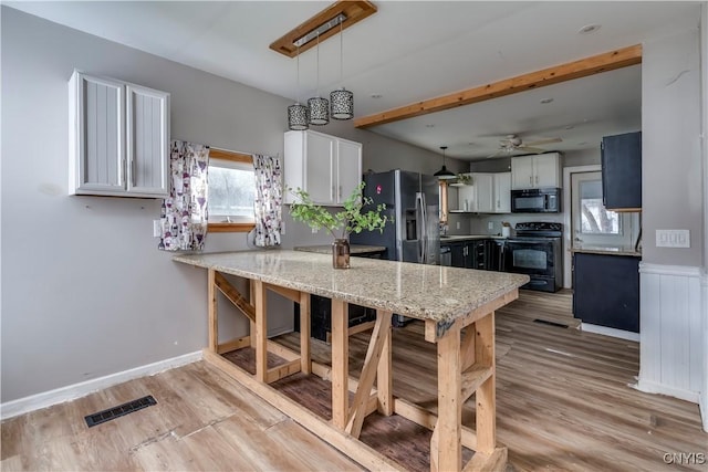 kitchen featuring white cabinets, pendant lighting, and black appliances