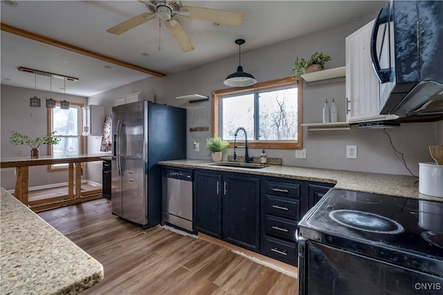 kitchen featuring blue cabinetry, hanging light fixtures, sink, and appliances with stainless steel finishes